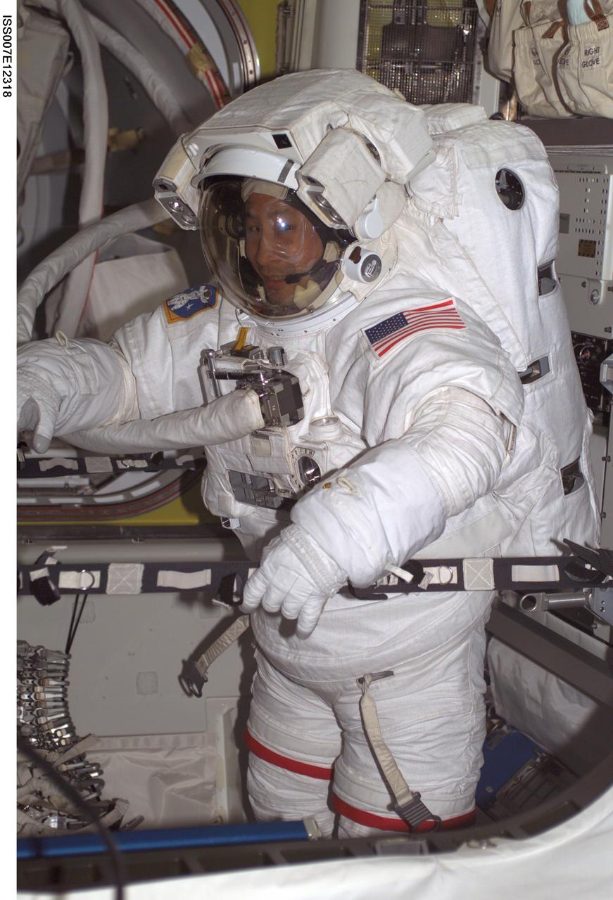 ISS007-E-12318 (7 August 2003) --- Astronaut Edward T. Lu, Expedition 7 NASA ISS science officer and flight engineer, is pictured wearing an Extravehicular Mobility Unit (EMU) spacesuit in the Quest airlock on the International Space Station (ISS).