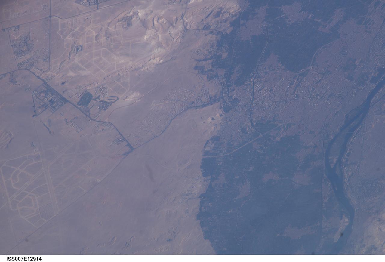 ISS007-E-12914 (18 August 2003) --- This view featuring Egypt’s Great pyramids of Giza (right center) was taken by an Expedition 7 crewmember onboard the International Space Station (ISS). Giza is a royal burial place, commissioned and built by pharaohs during the fourth dynasty around 2550 BC. Today, Giza is a rapidly growing region of Cairo. Population growth in Egypt continues to soar, leading to new construction. New roads for large new developments are obvious in the desert hills northwest and southwest of the pyramids.