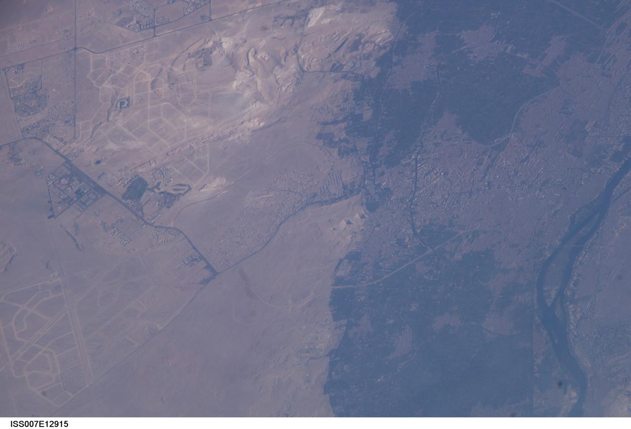 ISS007-E-12915 (18 August 2003) --- This view featuring Egypt’s Great pyramids of Giza (right center) was taken by an Expedition 7 crewmember onboard the International Space Station (ISS). Giza is a royal burial place, commissioned and built by pharaohs during the fourth dynasty around 2550 BC. Today, Giza is a rapidly growing region of Cairo. Population growth in Egypt continues to soar, leading to new construction. New roads for large new developments are obvious in the desert hills northwest and southwest of the pyramids.