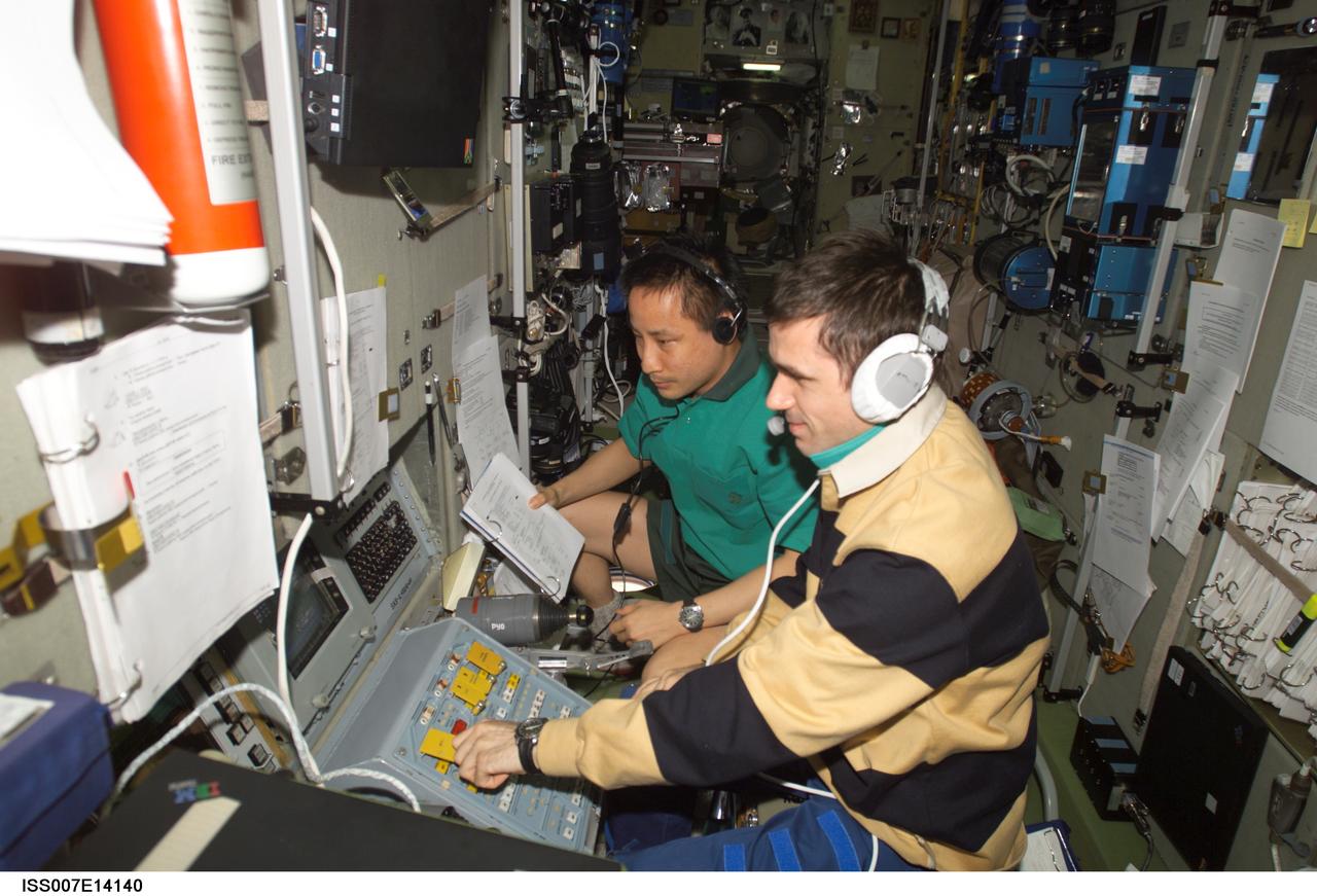ISS007-E-14140 (31 August 2003) --- Cosmonaut Yuri I. Malenchenko (foreground), Expedition 7 mission commander, and astronaut Edward T. Lu, NASA ISS science officer and flight engineer, work at the Simvol-Ts workstation in the Zvezda Service Module on the International Space Station (ISS) during the docking approach of the Progress 12 spacecraft. Malenchenko represents Rosaviakosmos.