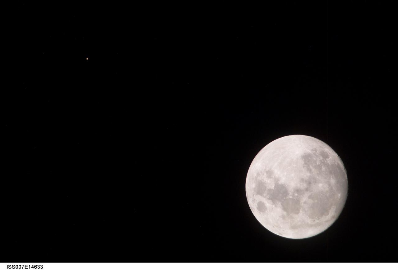 ISS007-E-14633 (9 September 2003) --- This view of a full Moon was photographed by one of the Expedition 7 crewmembers aboard the International Space Station (ISS). The view also includes Mars, which appears as a small dot.