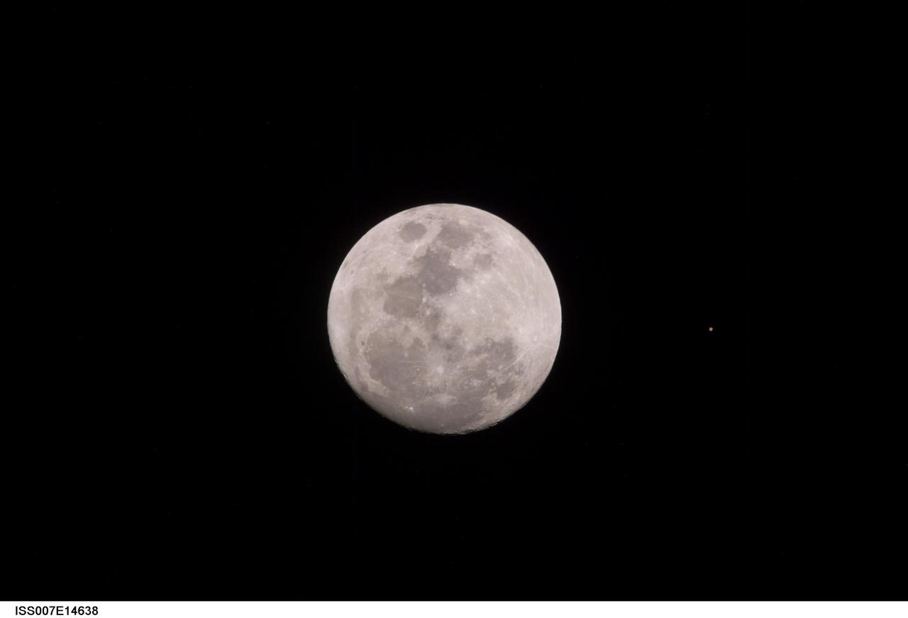 ISS007-E-14638 (9 September 2003) --- This view of a full Moon was photographed by one of the Expedition 7 crewmembers aboard the International Space Station (ISS). The view also includes Mars, which appears as a small dot.