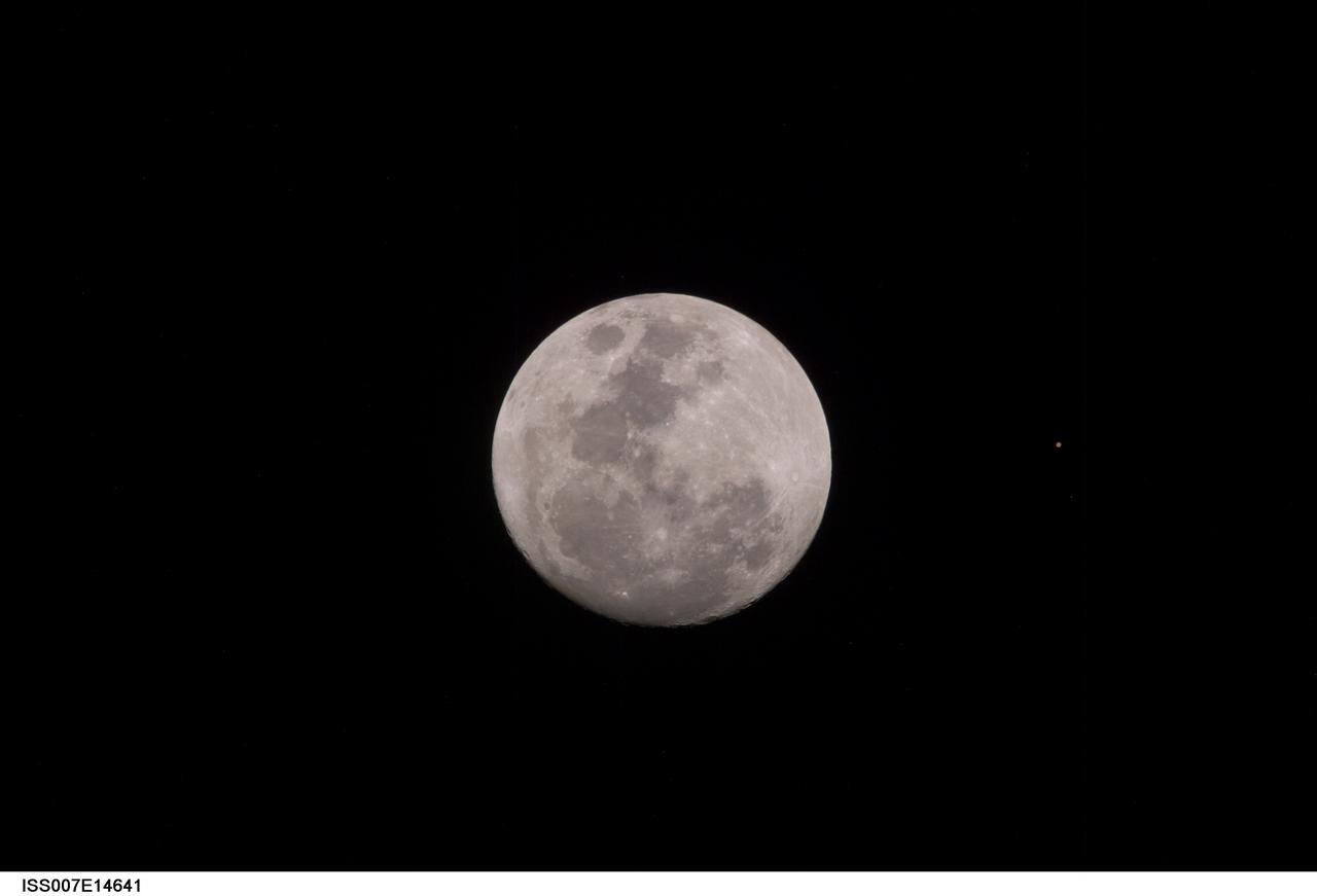 ISS007-E-14641 (9 September 2003) --- This view of a full Moon was photographed by one of the Expedition 7 crewmembers aboard the International Space Station (ISS). The view also includes Mars, which appears as a small dot.