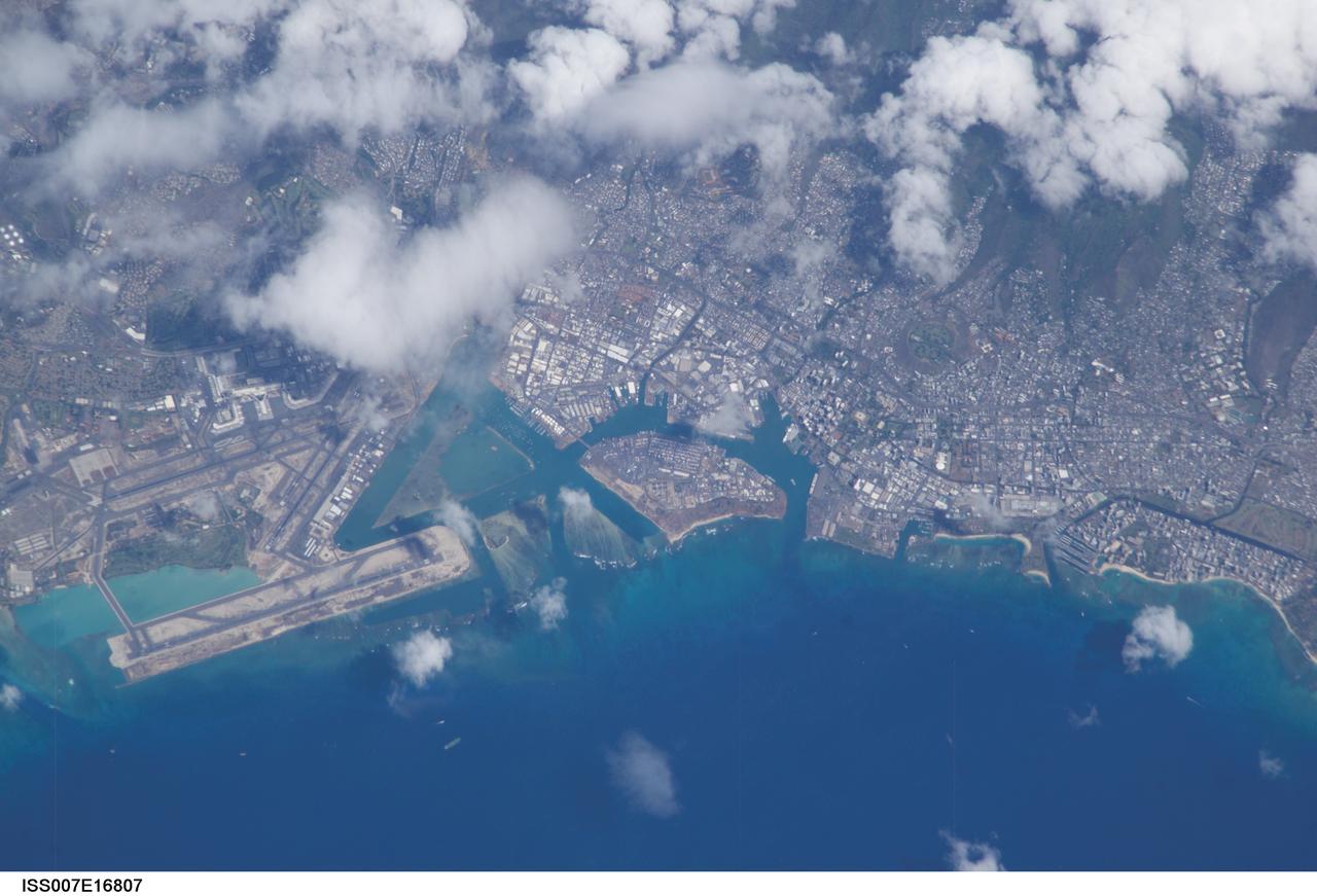 ISS007-E-16807 (8 October 2003) --- The Honolulu International Airport runway juts into the water on the left side of this image of Oahu, taken by an Expedition 7 crewmember onboard the International Space Station (ISS). In the center is Ke’ehi Lagoon and on the right is Sand Island.