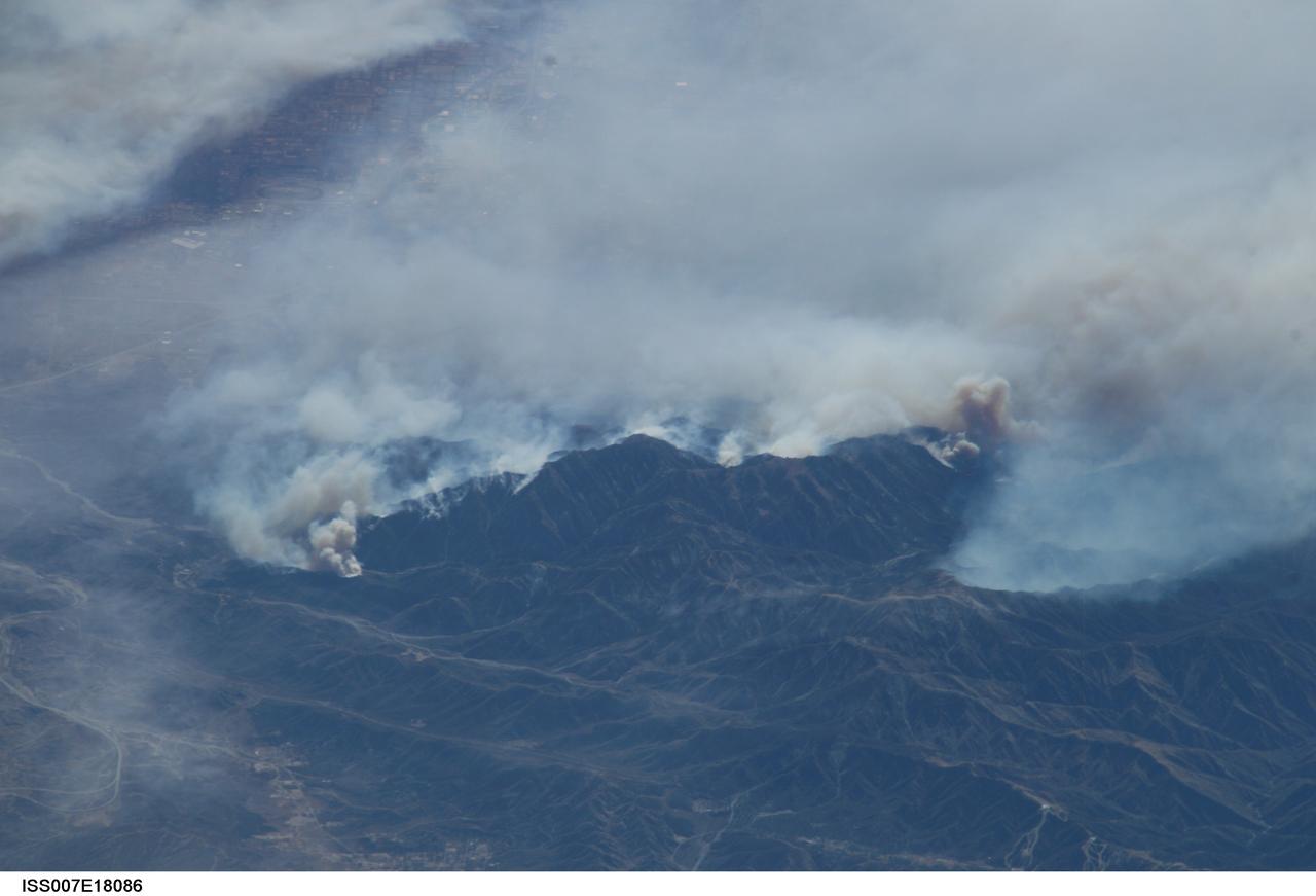 ISS007-E-18086 (26 October 2003) --- The fires in the San Bernardino Mountains, fueled by Santa Ana winds, burned out of control on the morning of Oct. 26, 2003, when this image and several others were taken from the International Space Station. This frame and image numbers 18087 and 18088 were taken at approximately 19:54 GMT, October 26, 2003 with a digital still camera equipped with a 400mm lens. Lake Arrowhead and Silverwood Lake are just out of frame. Content was provided by JSC&#0146;s Earth Observation Lab. The International Space Station Program {link to http://spaceflight.nasa.gov} supports the laboratory to help astronauts take pictures of Earth that will be of the greatest value to scientists and the public, and to make those images freely available on the Internet. Additional images taken by astronauts and cosmonauts can be viewed at the NASA/JSC Gateway to Astronaut Photography of Earth [link to http://eol.jsc.nasa.gov/].