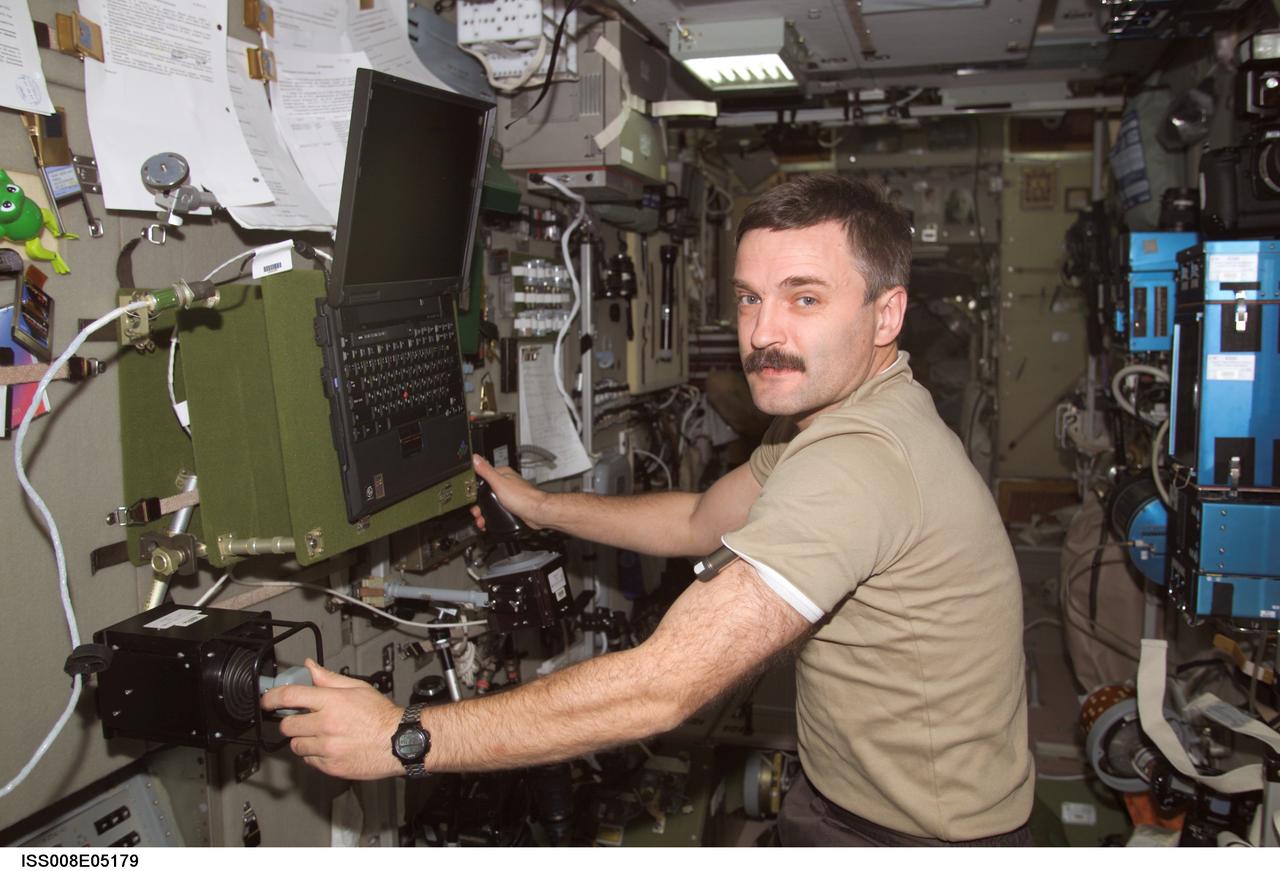 ISS008-E-05179 (31 October 2003) --- Cosmonaut Alexander Y. Kaleri, Expedition 8 flight engineer, works with the Russian biomedical &#0147;Pilot&#0148; experiment (MBI-15) in the Zvezda Service Module on the International Space Station (ISS). The experiment, which looks at psychological and physiological changes in crew performance during long-duration spaceflight, requires a worktable, ankle restraint system and two control handles for testing piloting skill. Kaleri represents Rosaviakosmos.