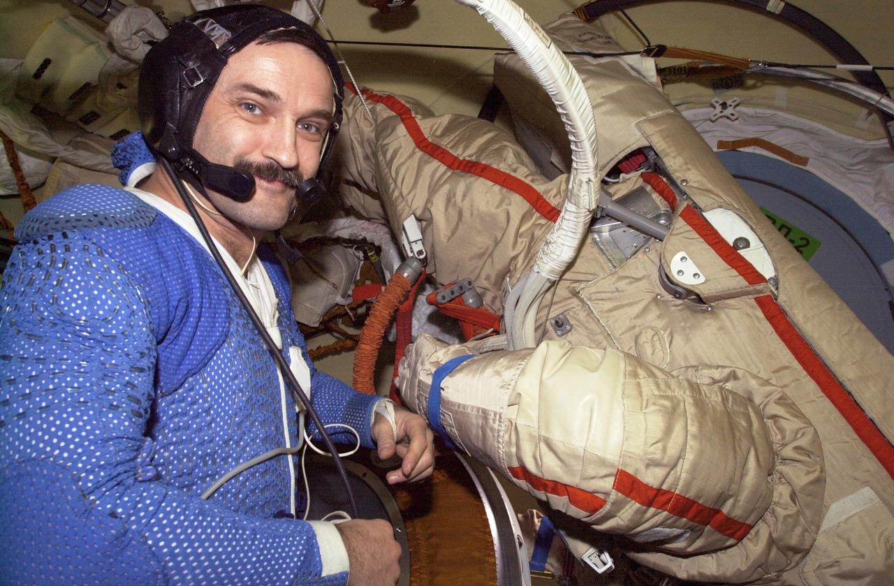 ISS008-E-05880 (November 2003) --- Cosmonaut Alexander Y. Kaleri, Expedition 8 flight engineer, attired in his thermal undergarment prior to donning a Russian Orlan spacesuit (right), is pictured in the Pirs Docking Compartment on the International Space Station (ISS). Kaleri represents Rosaviakosmos.