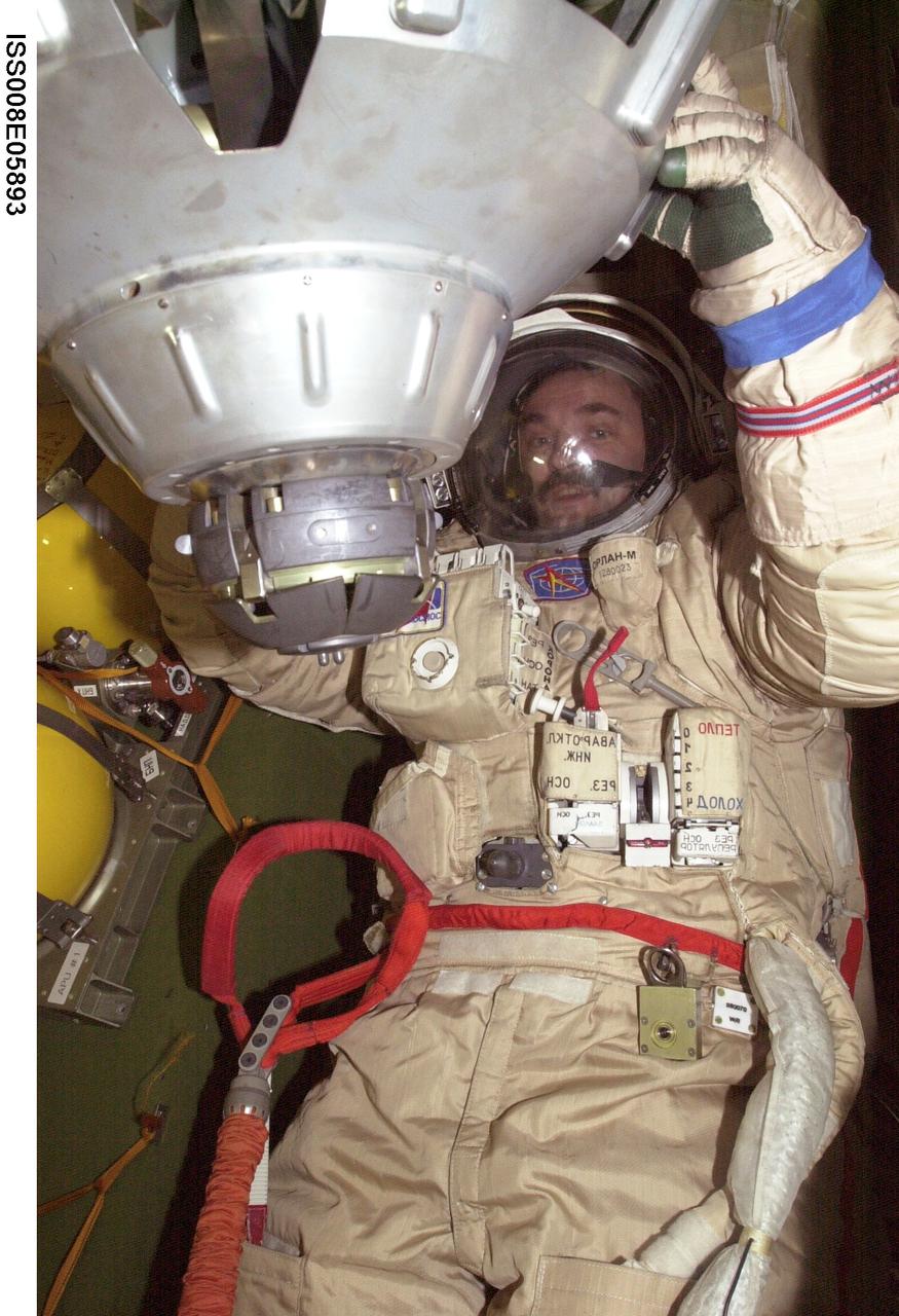 ISS008-E-05893 (November 2003) --- Cosmonaut Alexander Y. Kaleri, Expedition 8 flight engineer, attired in his Russian Orlan spacesuit, is pictured in a Soyuz spacecraft docked to the Pirs Docking Compartment on the International Space Station (ISS). Kaleri represents Rosaviakosmos.