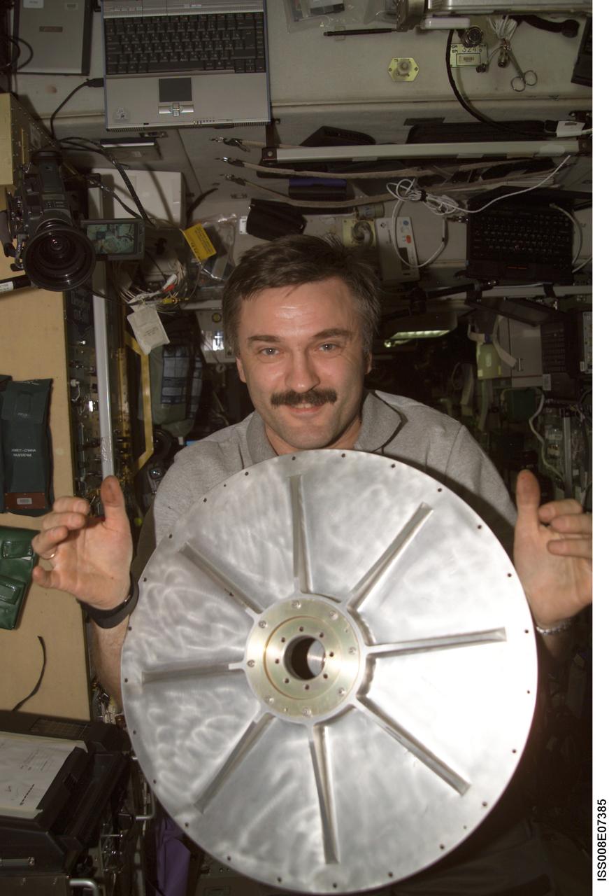 ISS008-E-07385 (9 December 2003) --- Cosmonaut Alexander Y. Kaleri, Expedition 8 flight engineer, holds the top end-cap for the Treadmill Vibration Isolation System (TVIS) gyroscope in the Zvezda Service Module on the International Space Station (ISS). Kaleri represents Rosaviakosmos.