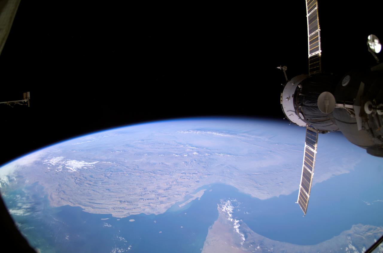 ISS008-E-12570 (22 January 2004) --- Backdropped by Earth&#0146;s horizon and the blackness of space, an unpiloted Progress supply vehicle docked to the International Space Station (ISS) was photographed by one of the Expedition 8 crewmembers.  Parts of Iran, the United Arab Emirates, Oman, Strait of Hormuz and the Persian Gulf are also visible.