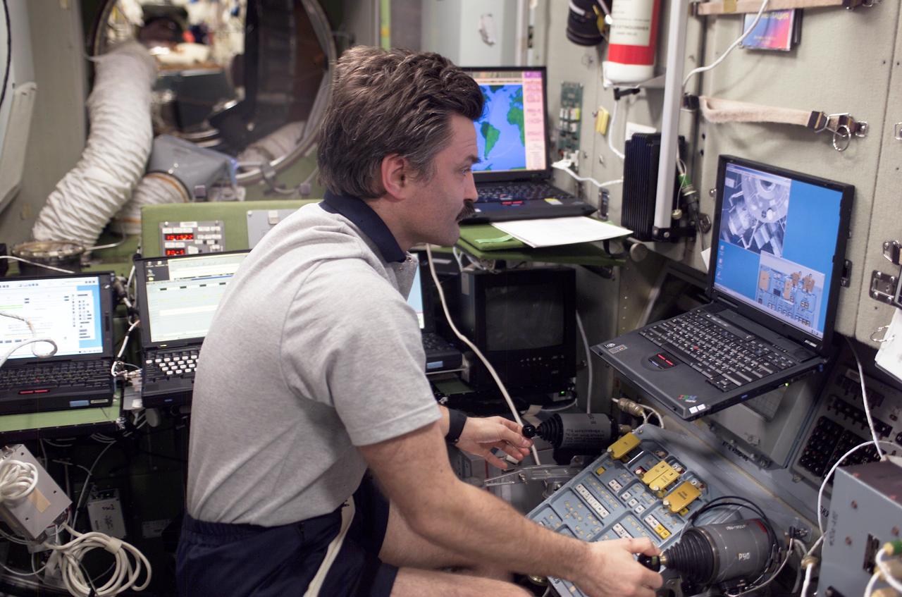 ISS008-E-14073 (30 January 2004) --- Cosmonaut Alexander Y. Kaleri, Expedition 8 flight engineer, practices docking procedures with the manual TORU rendezvous system in the Zvezda Service Module on the International Space Station (ISS) in preparation for the docking of the Progress 13 on January 31. With the manual TORU mode, Kaleri can perform necessary guidance functions from Zvezda via two hand controllers in the event of a failure of the &#0147;Kurs&#0148; automated rendezvous and docking (AR&D) of the Progress. Kaleri represents Rosaviakosmos.