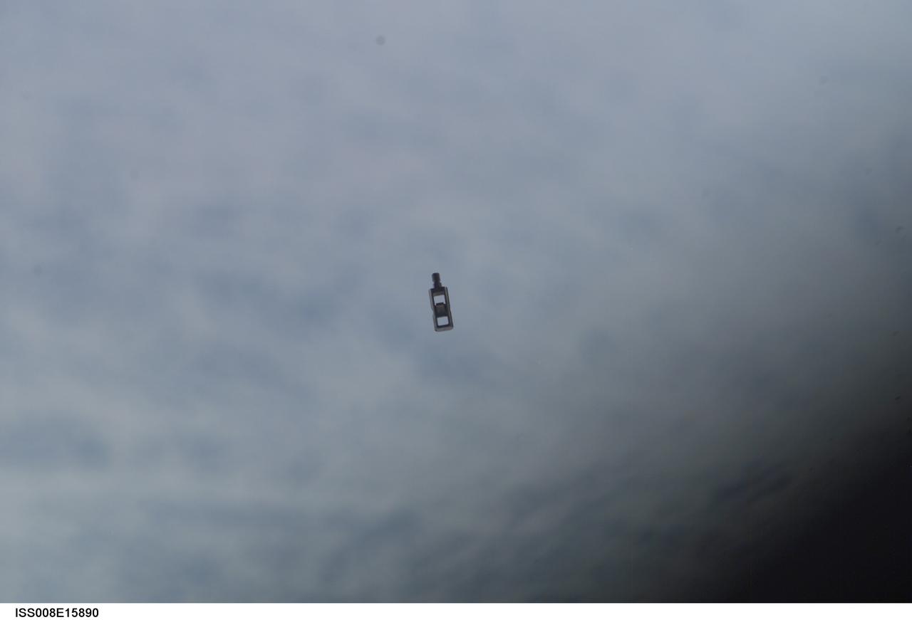 ISS008-E-15890 (15 February 2004) --- This image was taken from the International Space Station (ISS) Feb 15 and shows a small piece of debris reported by the Expedition 8 crew. The debris, which has been identified as a two-inch "eyebolt" from a solar array on the Progress cargo craft that recently docked with the Station, drifted slowly away and posed no problems for the complex. The eyebolt is from a system that is used with the arrays during the Progress' launch and serves no function after the arrays are deployed in orbit.