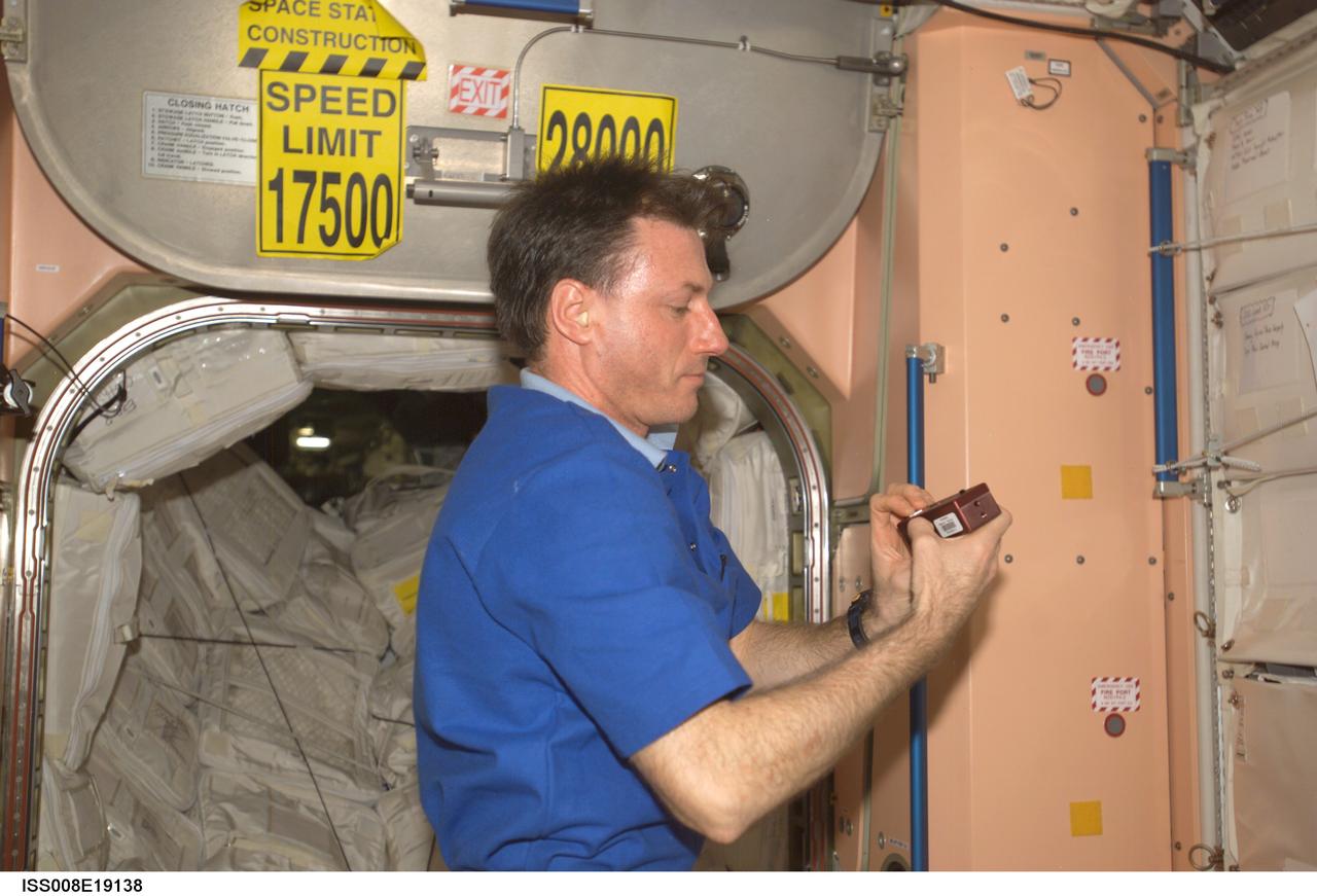ISS008-E-19138 (24 March 2004) --- Astronaut C. Michael Foale, Expedition 8 commander and NASA ISS science officer, does a check of the Synchronized Position Hold, Engage, Reorient, Experimental Satellites (SPHERES) Beacon / Beacon Tester in the Unity node of the International Space Station.