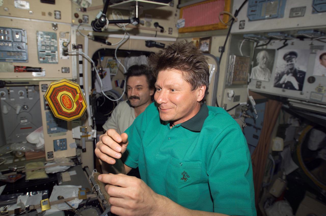 ISS008-E-22002 (22 April 2004) --- Cosmonaut Gennady I. Padalka, Expedition 9 commander, spins a box of chocolates as cosmonaut Alexander Y. Kaleri, Expedition 8 flight engineer, looks on in the Zvezda Service Module on the International Space Station (ISS). Padalka and Kaleri represent Russia’s Federal Space Agency.