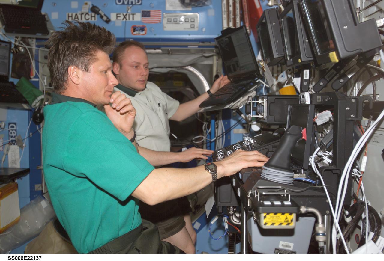ISS008-E-22137 (24 April 2004) --- Cosmonaut Gennady I. Padalka (foreground), Expedition 9 commander, and astronaut Edward M. (Mike) Fincke, NASA ISS science officer and flight engineer, participate in a familiarization session with the Mobile Service System (MSS) and hands-on experience with the Canadarm2, or Space Station Remote Manipulator System (SSRMS) in the Destiny laboratory of the International Space Station (ISS). Padalka represents Russia’s Federal Space Agency.