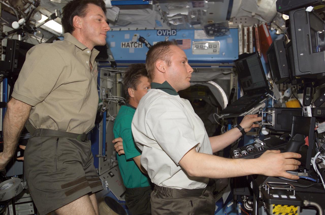 ISS008-E-22156 (24 April 2004) --- Astronaut C. Michael Foale (left), Expedition 8 commander and NASA ISS science officer, take cosmonaut Gennady I. Padalka (partially obscured), Expedition 9 commander, and astronaut Edward M. (Mike) Fincke, NASA ISS science officer and flight engineer, through a familiarization session with the Mobile Service System (MSS) and hands-on experience with the Canadarm2, or Space Station Remote Manipulator System (SSRMS) in the Destiny laboratory of the International Space Station (ISS). Padalka represents Russia&#0146;s Federal Space Agency.