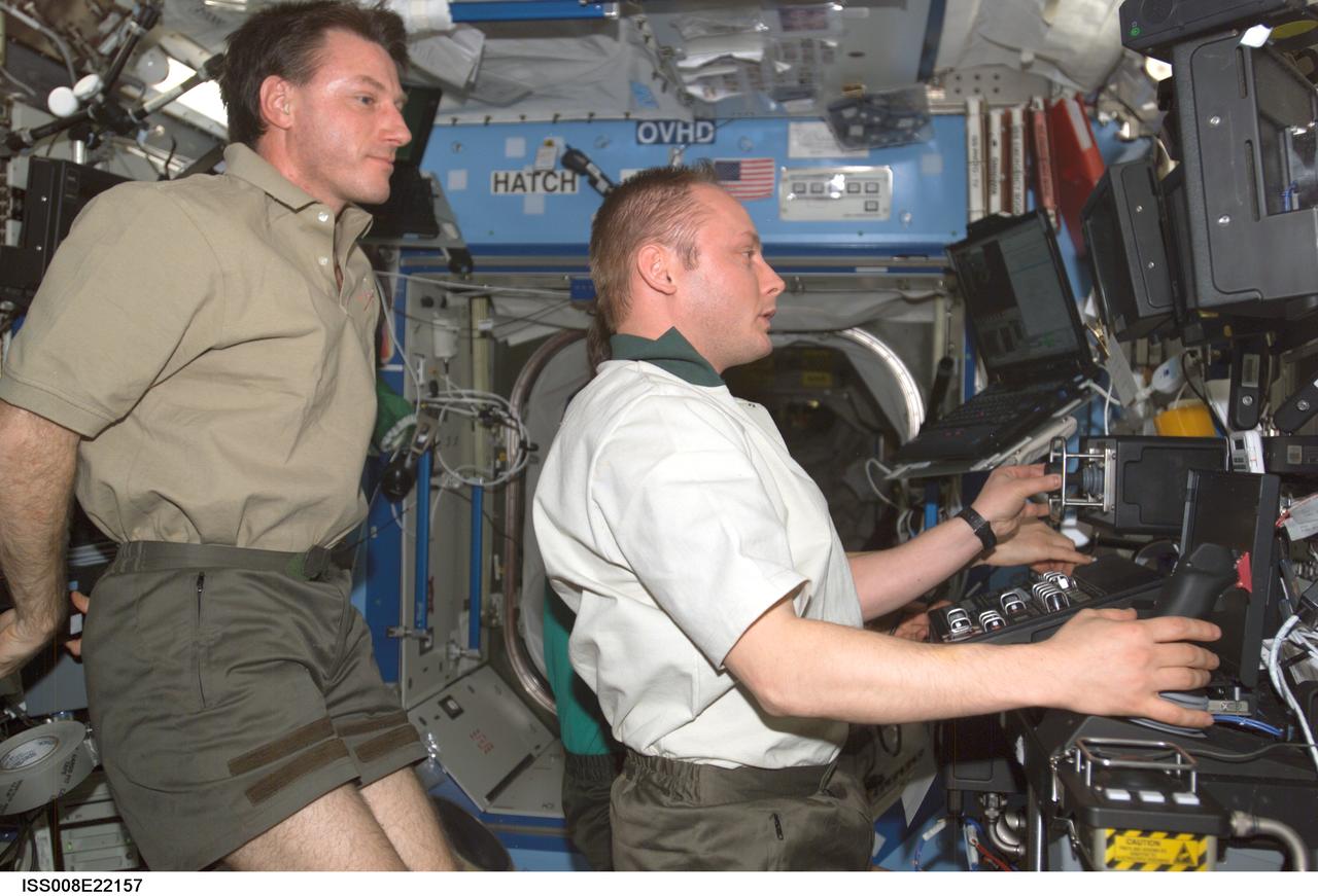 ISS008-E-22157 (24 April 2004) --- Astronaut C. Michael Foale (left), Expedition 8 commander and NASA ISS science officer, take cosmonaut Gennady I. Padalka (partially obscured), Expedition 9 commander, and astronaut Edward M. (Mike) Fincke, NASA ISS science officer and flight engineer, through a familiarization session with the Mobile Service System (MSS) and hands-on experience with the Canadarm2, or Space Station Remote Manipulator System (SSRMS) in the Destiny laboratory of the International Space Station (ISS). Padalka represents Russia&#0146;s Federal Space Agency.