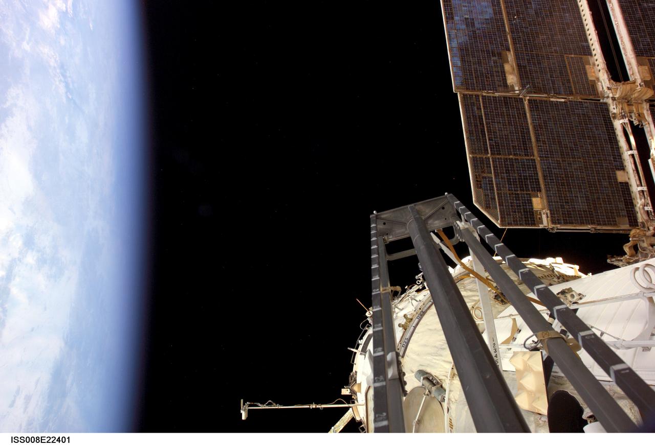 ISS008-E-22401 (2 March 2004) --- This view, taken during Expedition 8 extravehicular activity (EVA), shows the Pirs Docking Compartment Portable Work Station and the Zvezda Service Module of the International Space Station (ISS), backdropped by the blackness of space and Earth&#0146;s horizon.