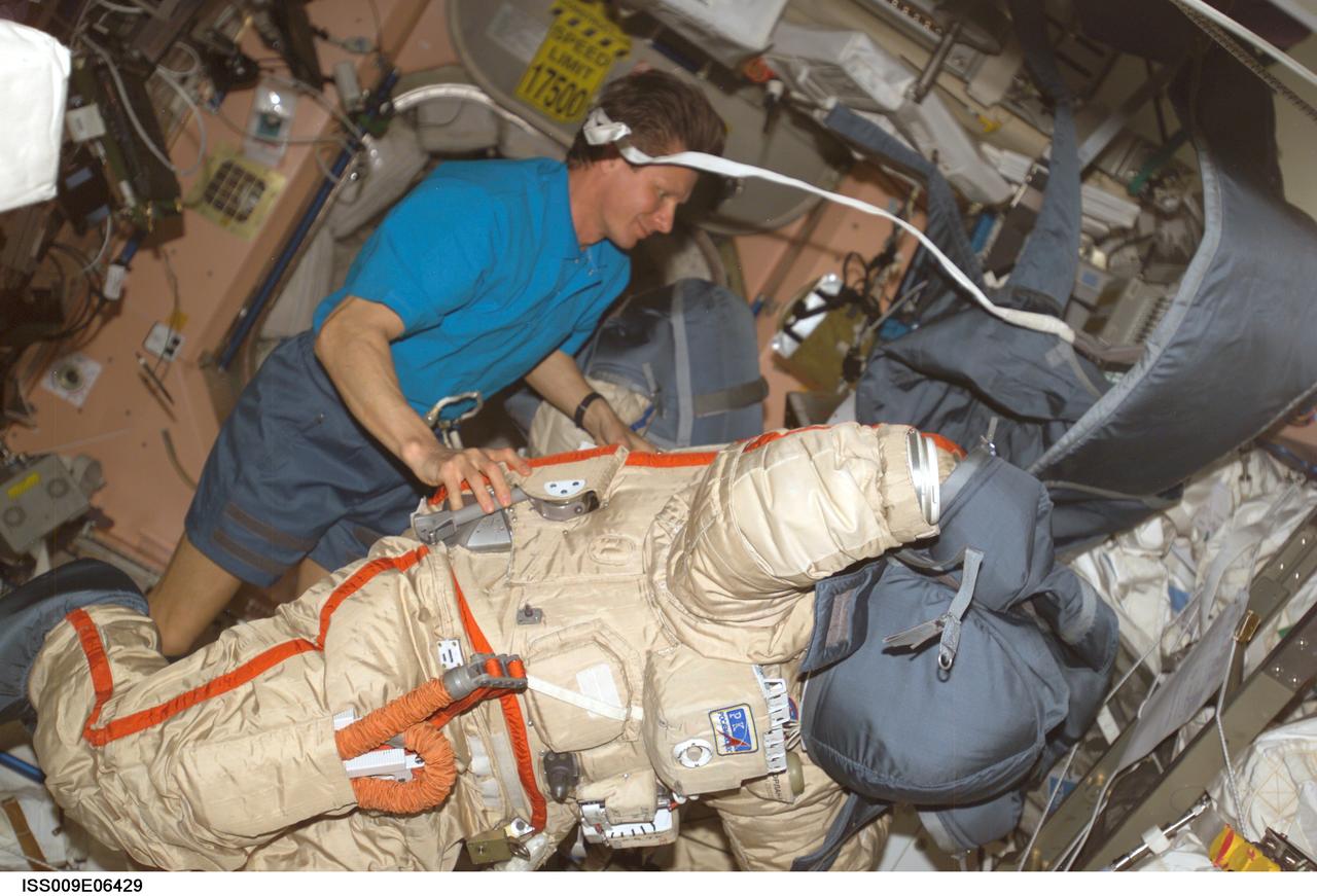 ISS009-E-06429 (10 May 2004) --- Cosmonaut Gennady I. Padalka, Expedition 9 commander representing Russia’s Federal Space Agency, performs a suit check on the Russian Orlan spacesuit in the Unity node of the International Space Station (ISS).