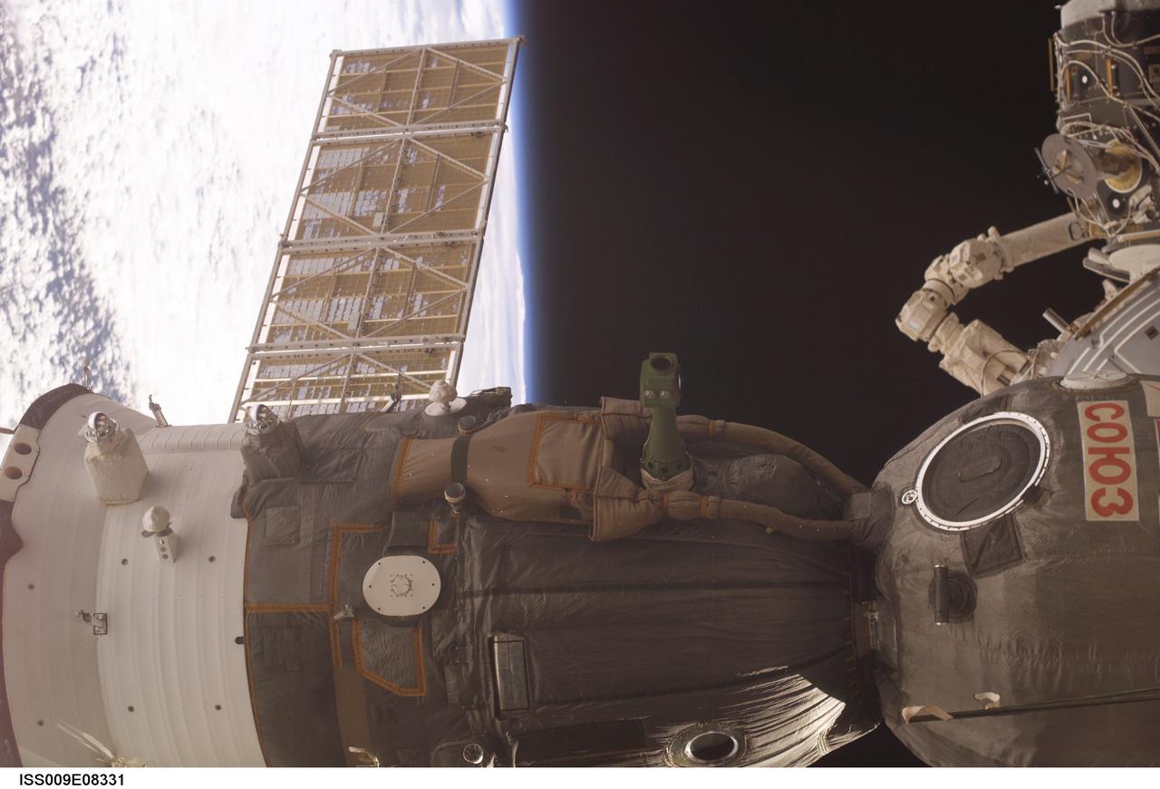 ISS009-E-08331 (24 May 2004) --- The blackness of space and Earth’s horizon provide the backdrop for this scene of the Soyuz TMA-4 spacecraft, docked to the Zarya functional cargo block (FGB) nadir port of the International Space Station (ISS). The scene was photographed by an Expedition 9 crewmember.