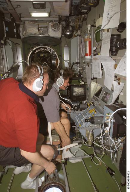 NASA image: Fincke watches as Padalka at the Simvol-Ts workstation during Progress 14P docking approach OPS on Expedition 9