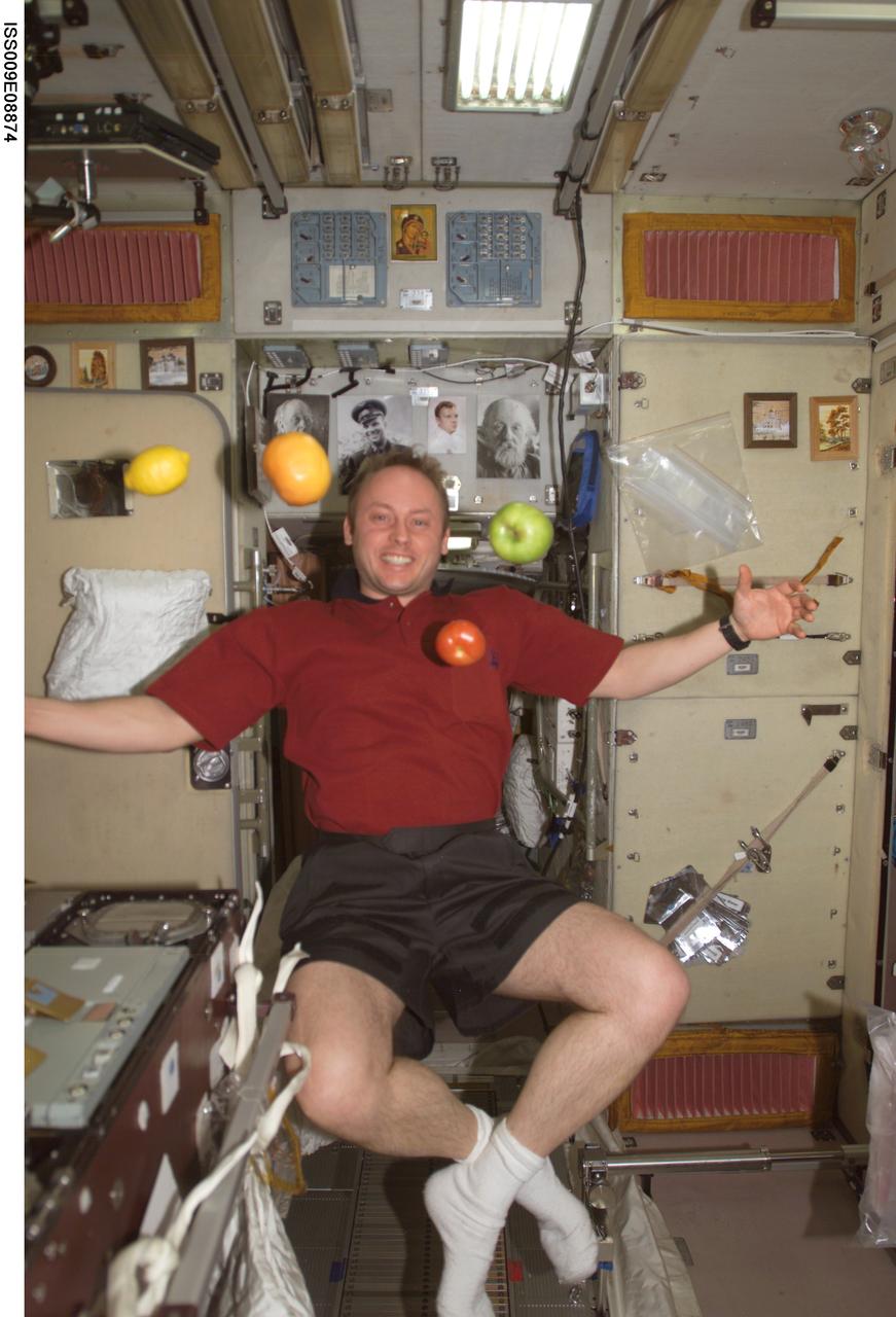 ISS009-E-08874 (27 May 2004) --- Astronaut Edward M. (Mike) Fincke, Expedition 9 NASA ISS science officer and flight engineer, is pictured near fresh fruit floating freely in the Zvezda Service Module of the International Space Station (ISS).