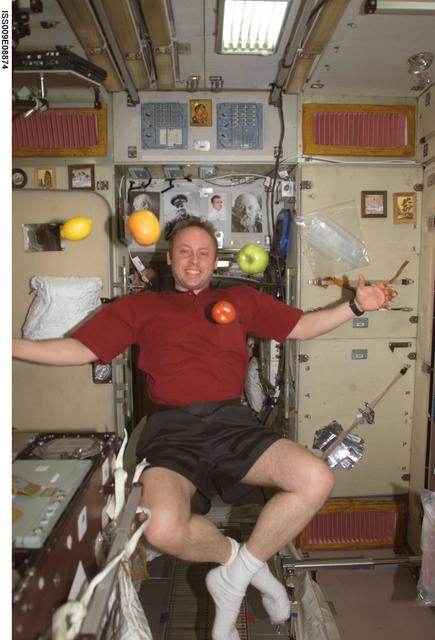 NASA image: Fincke watches as fruit floats in the Service Module during Expedition 9