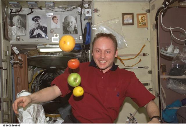 NASA image: Fincke watches as fruit floats in the Service Module during Expedition 9