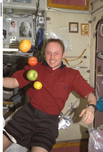 NASA image: Fincke watches as fruit floats in the Service Module during Expedition 9