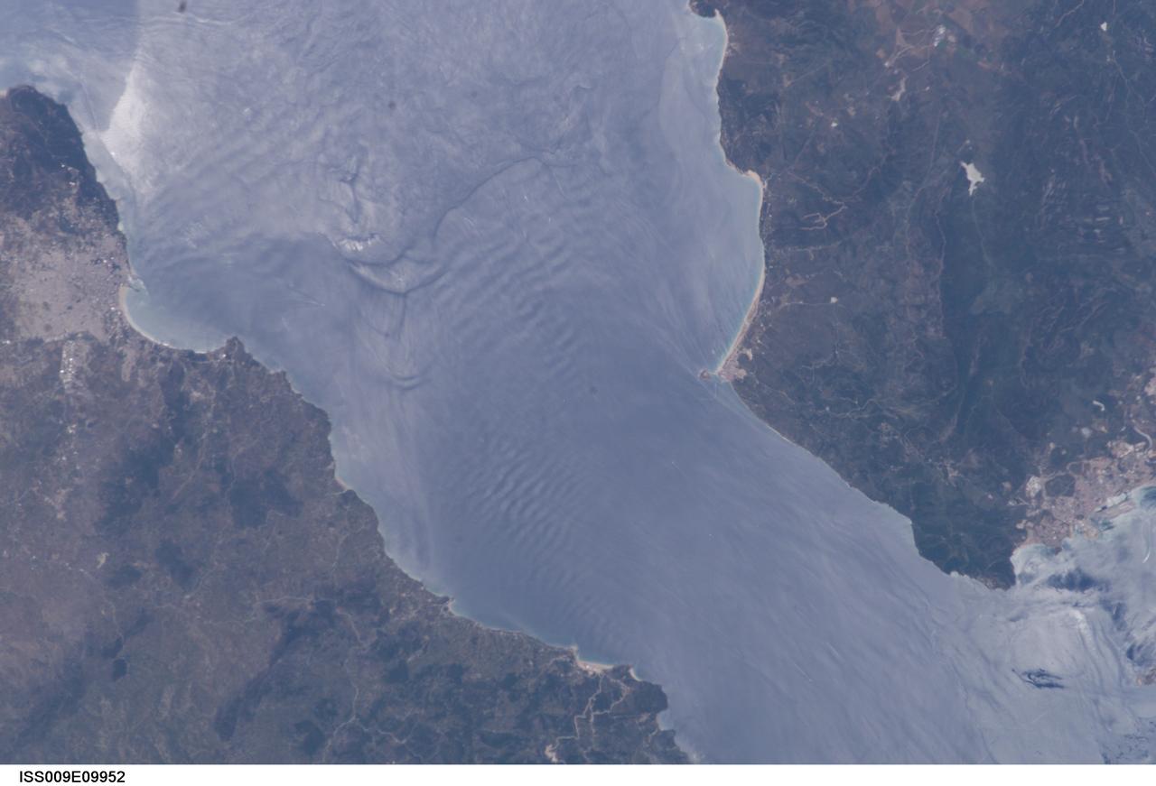ISS009-E-09952 (3 June 2004) --- Large internal waves in the Strait of Gibraltar are featured in this scene photographed by an Expedition 9 crewmember on the International Space Station (ISS). These subsurface internal waves occur at depths of about 100 meters, but appear in the sun glint as giant swells flowing eastward into the Mediterranean Sea. This image was merged with image ISS009-E-09954 to create a mosaic, which can be viewed on http://eol.jsc.nasa.gov.