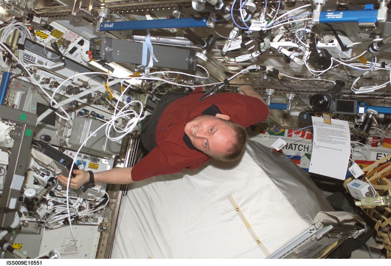 ISS009-E-10551 (4 June 2004) --- Astronaut Edward M. (Mike) Fincke, Expedition 9 NASA ISS science officer and flight engineer, moves the Zero-G Storage Rack (ZSR) in the Destiny laboratory of the International Space Station (ISS) in order to retrieve the spare Remote Power Controller Module (RPCM), scheduled to replace the failed RPCM on the S0 (S-Zero) Truss. Fincke is positioned above the ZSR, which has been pulled from the Express Rack.