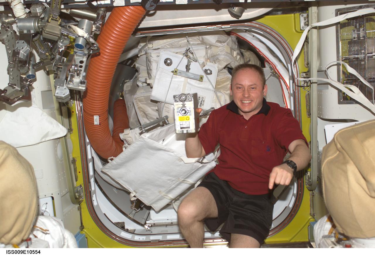 ISS009-E-10554 (4 June 2004) --- Astronaut Edward M. (Mike) Fincke, Expedition 9 NASA ISS science officer and flight engineer, holds the spare Remote Power Controller Module (RPCM) in the Quest airlock of the International Space Station (ISS). The spare is scheduled to replace the failed RPCM on the S0 (S-Zero) Truss.