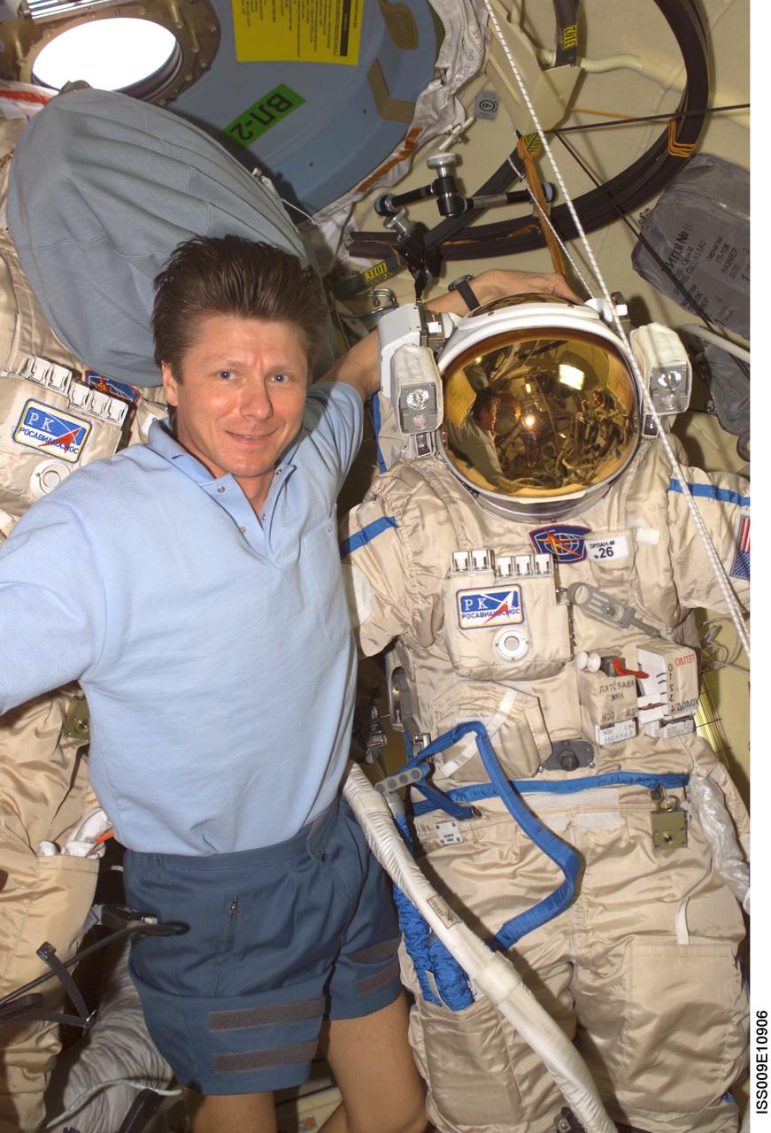 ISS009-E-10906 (9 June 2004) --- Cosmonaut Gennady I. Padalka, Expedition 9 commander representing Russia’s Federal Space Agency, is pictured with his Russian Orlan spacesuit in the Pirs Docking Compartment of the International Space Station (ISS). Extravehicular activity (EVA) is scheduled for June 24.