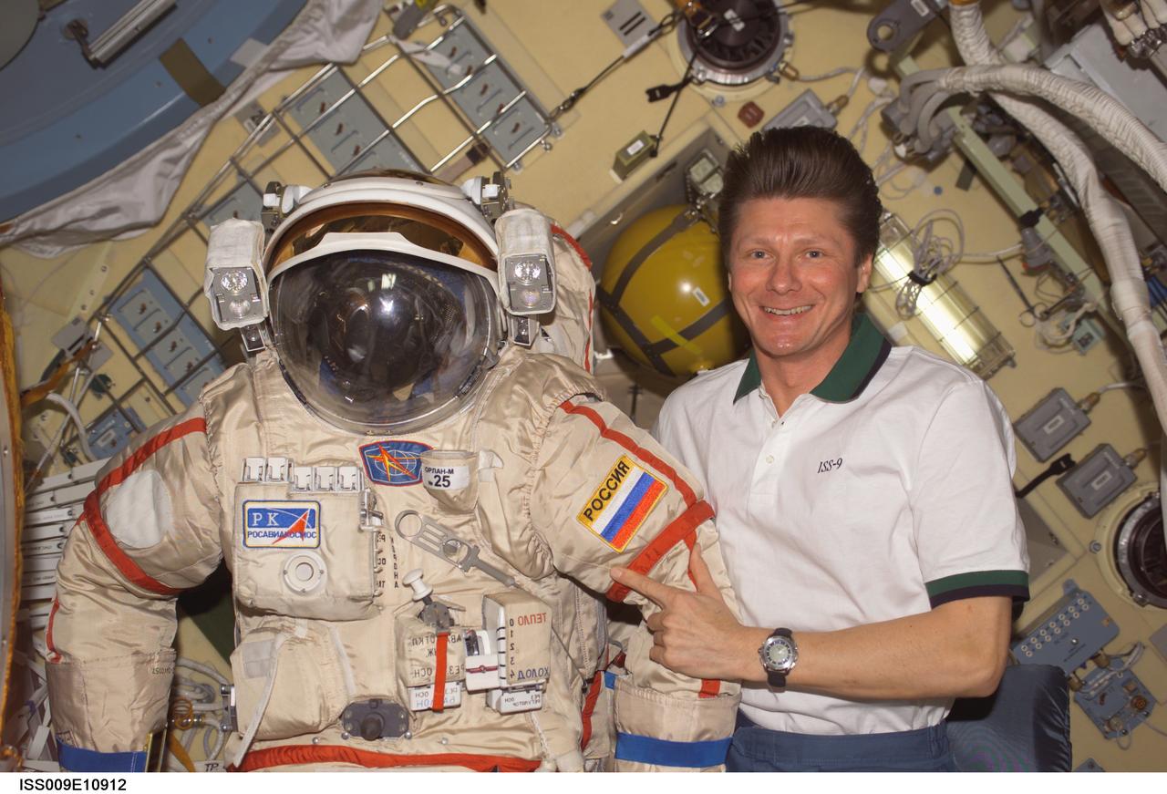 ISS009-E-10912 (10 June 2004) --- Cosmonaut Gennady I. Padalka, Expedition 9 commander representing Russia’s Federal Space Agency, is pictured with his Russian Orlan spacesuit in the Pirs Docking Compartment of the International Space Station (ISS). Extravehicular activity (EVA) is scheduled for June 24.