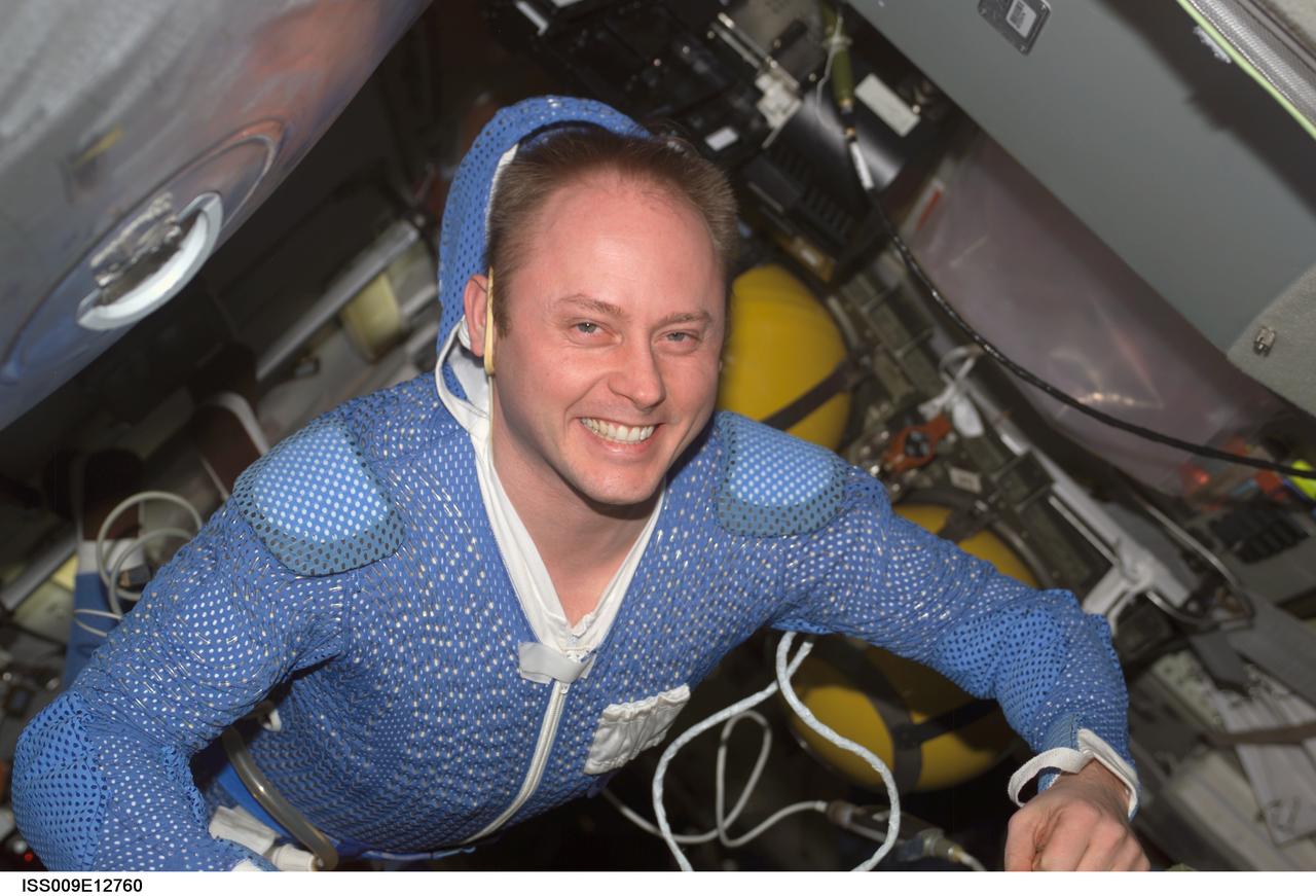 ISS009-E-12760 (24 June 2004) --- Astronaut Edward M. (Mike) Fincke, Expedition 9 NASA ISS science officer and flight engineer, wearing thermal undergarment, floats in the Pirs Docking Compartment of the International Space Station (ISS).