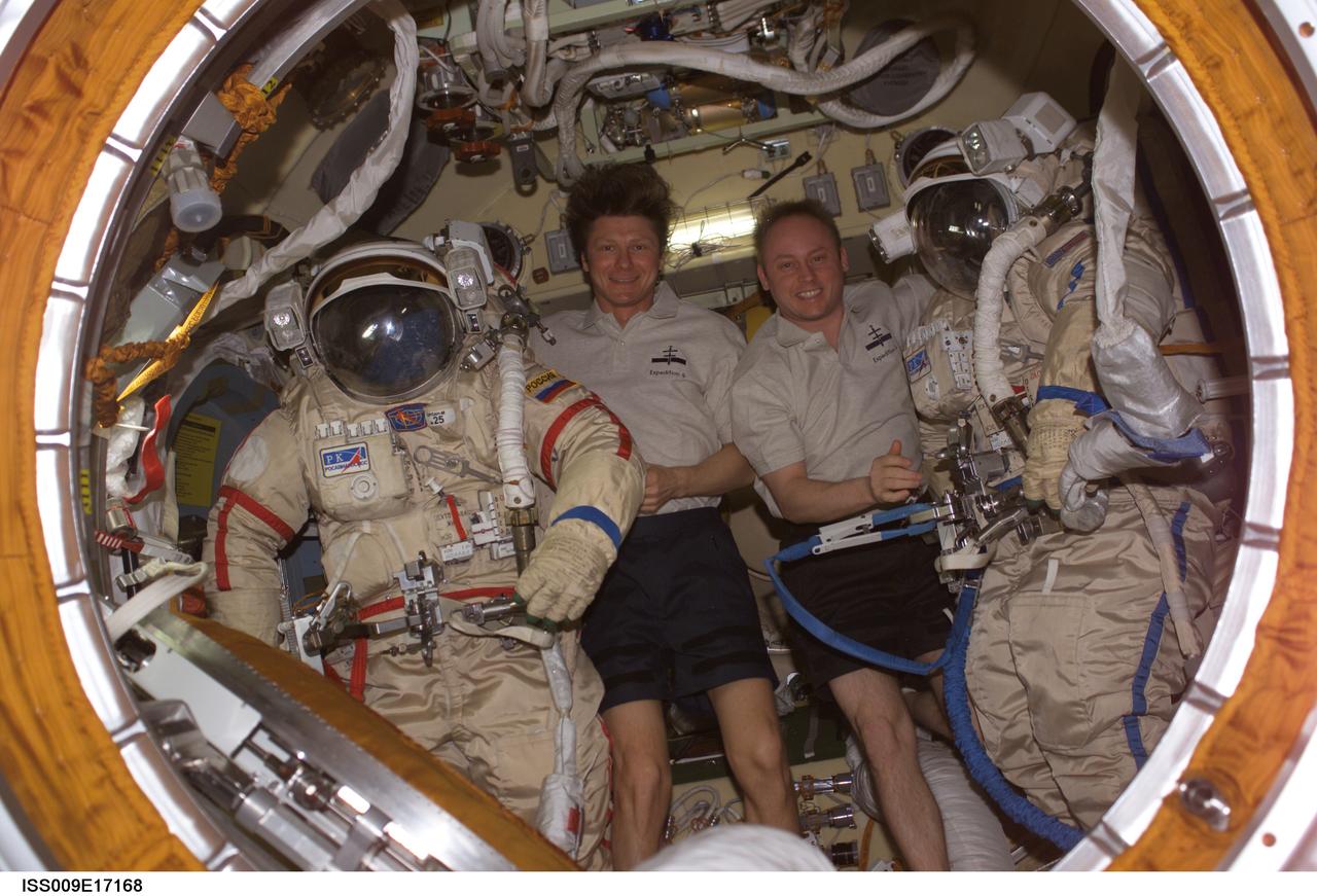 ISS009-E-17168 (2 August 2004) --- Cosmonaut Gennady I. Padalka (left), Expedition 9 commander representing Russia’s Federal Space Agency, and astronaut Edward M. (Mike) Fincke, NASA ISS science officer and flight engineer, pose with their Russian Orlan spacesuits in the Pirs Docking Compartment of the International Space Station (ISS).