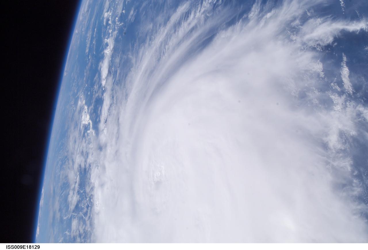 ISS009-E-18129 (21:08:57 GMT, 12 August 2004) --- Less than a minute after ISS009-E-18123, the Expedition 9 crew captured this more detailed view of Hurricane Charley looking southward. The small eye is visible, but not cloud-free yet. Spiraling streaks of high cirrus clouds around the south southern and western edges of the storm indicate the pronounced outflow of air above the storm.