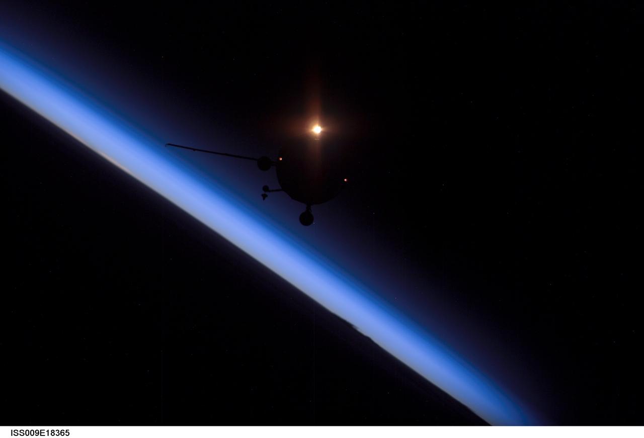 ISS009-E-18365 (14 August 2004) --- Backdropped against the blackness of space and airglow of Earth&#0146;s horizon, an unpiloted Progress supply vehicle approaches the International Space Station (ISS). The Progress 15 resupply craft launched at 12:03 a.m. (CDT) on August 11, 2004 from the Baikonur Cosmodrome in Kazakhstan to deliver almost three tons of food, fuel, oxygen, water and supplies to the Expedition 9 crewmembers onboard the Station. Progress docked to the aft port of the Zvezda Service Module at 12:01 a.m. (CDT) on August 14 as the two craft flew 225 statute miles over central Asia.