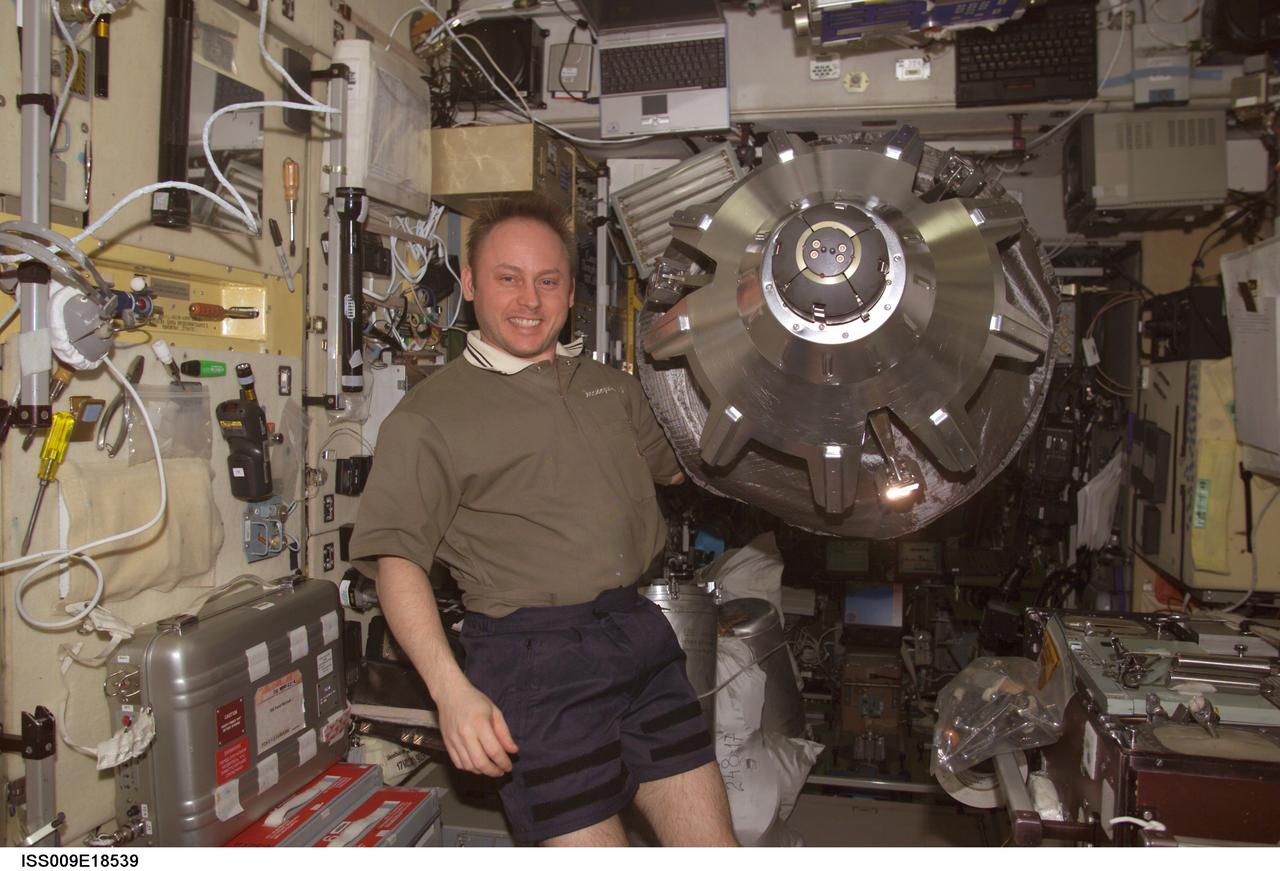 ISS009-E-18539 (14 August 2004) --- Astronaut Edward M. (Mike) Fincke, Expedition 9 NASA ISS science officer and flight engineer, holds the Progress 15 supply vehicle probe-and-cone docking mechanism in the Zvezda Service Module of the International Space Station (ISS).