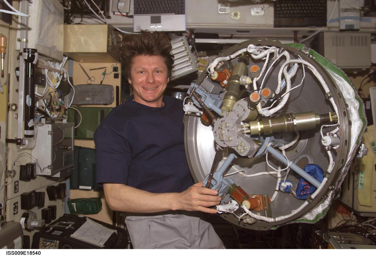 ISS009-E-18540 (14 August 2004) --- Cosmonaut Gennady I. Padalka, Expedition 9 commander representing Russia’s Federal Space Agency, holds the Progress 15 supply vehicle probe-and-cone docking mechanism in the Zvezda Service Module of the International Space Station (ISS).