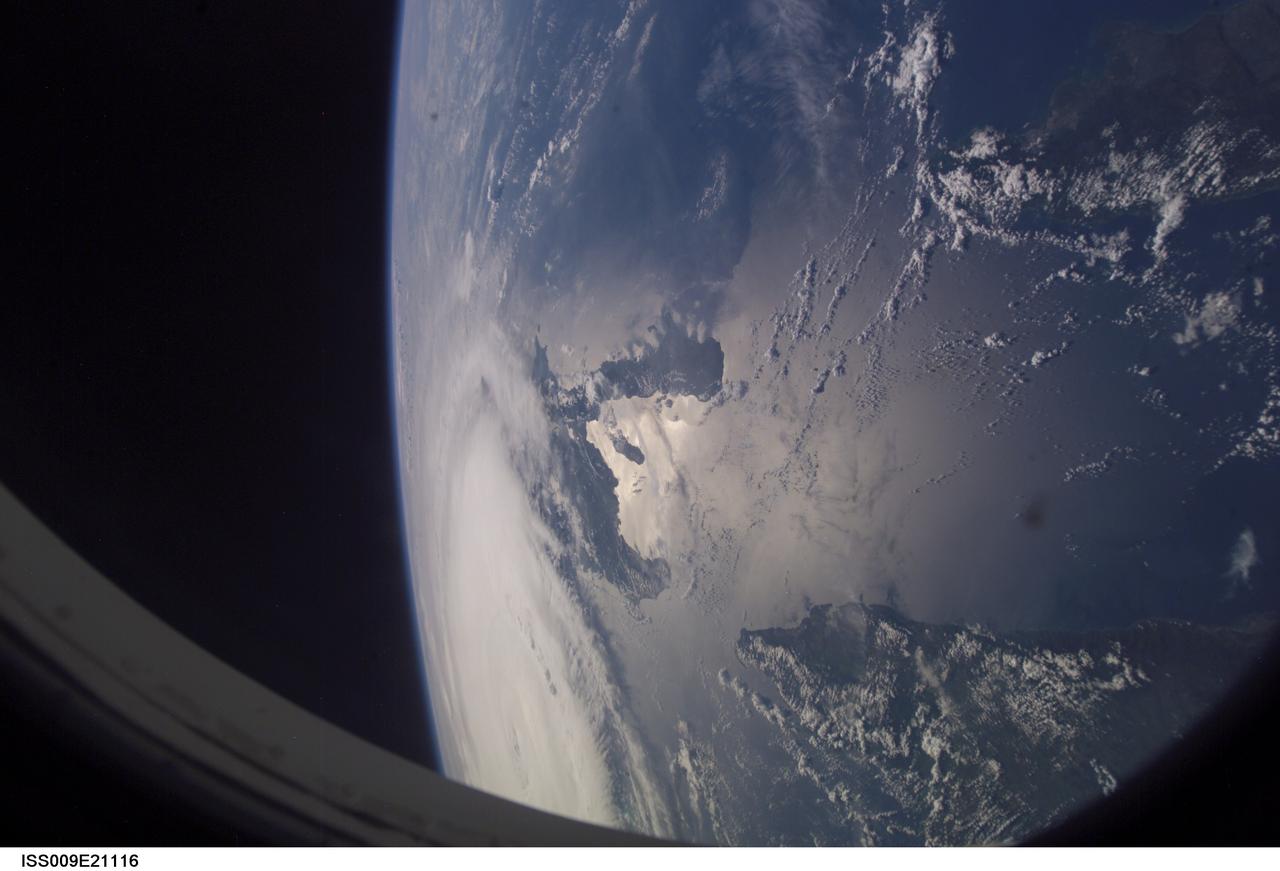 ISS009-E-21116 (1 Sept. 2004) -- Astronaut Edward M. (Mike) Fincke, aboard the International Space Station (ISS) at an altitude of about 230 miles, took this photo of Hurricane Frances early Sept. 1. Part of the large system is obscured by the portal. The Guantanimo Bay area of Cuba appears near frame's edge and part of Hispaniola is pictured near frame center. Sunglint alters the natural colors in this scene.
