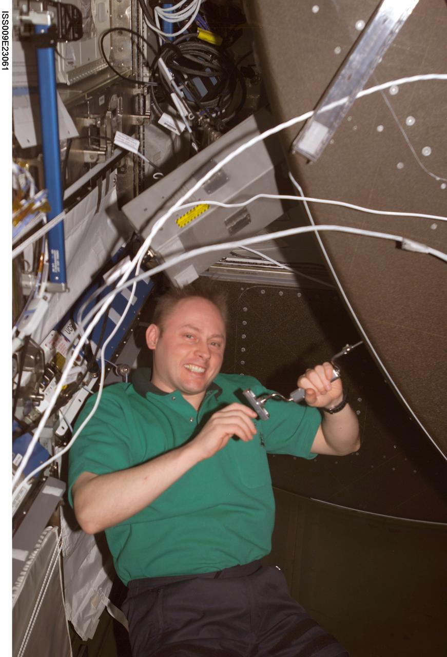 ISS009-E-23061 (16 September 2004) --- Astronaut Edward M. (Mike) Fincke, Expedition 9 NASA ISS science officer and flight engineer, uses a drill to unfasten a panel on the CHeCS Rack in the Destiny laboratory of the International Space Station (ISS). Fincke was about to perform an inspection of the Avionics Air Assembly.
