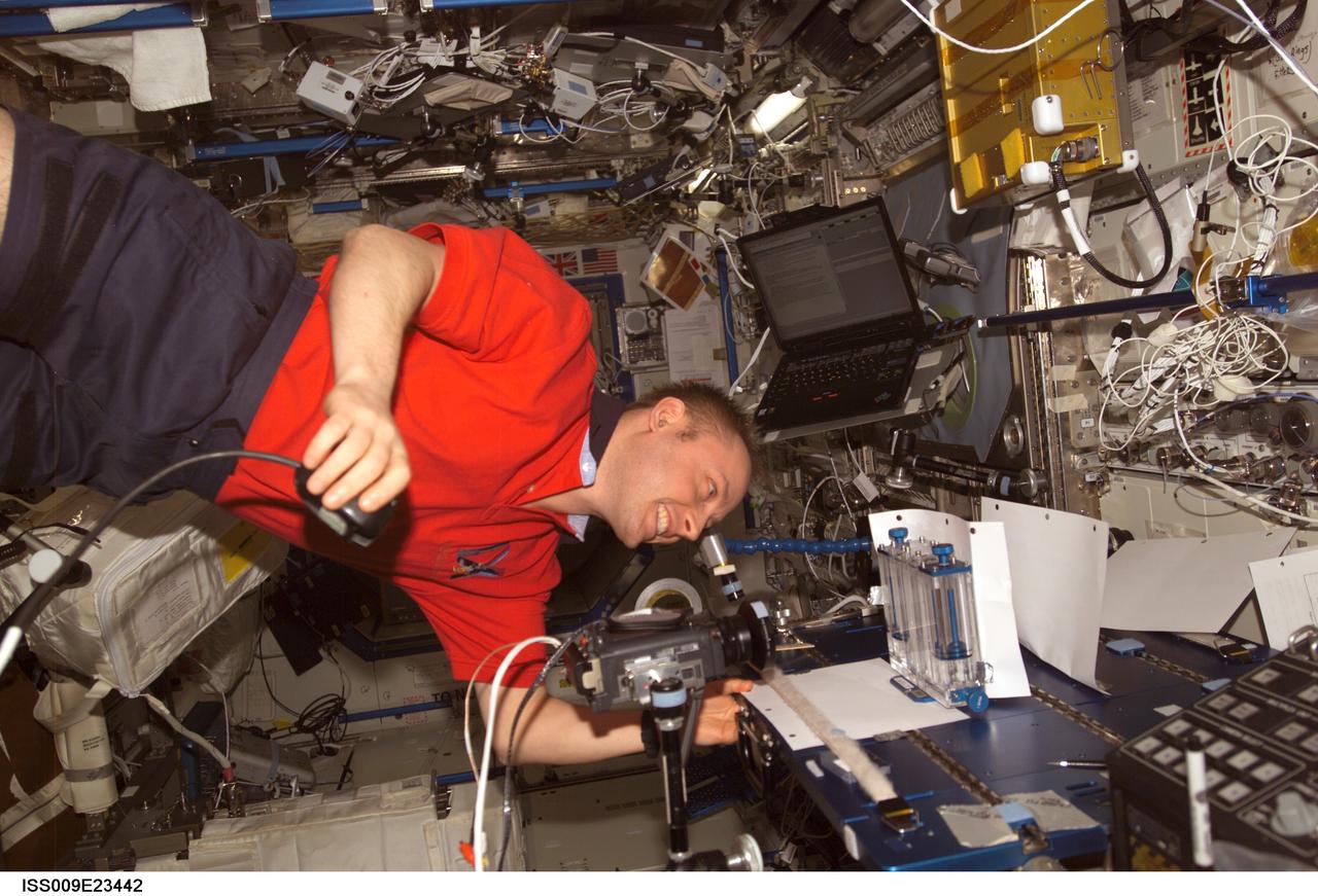 ISS009-E-23442 (18 September 2004) --- Astronaut Edward M. (Mike) Fincke, Expedition 9 NASA ISS science officer and flight engineer, performs one of multiple tests of the Capillary Flow Experiment (CFE) investigation in the Destiny laboratory of the International Space Station (ISS). CFE observes the flow of fluid, in particular capillary phenomena, in micro-G.