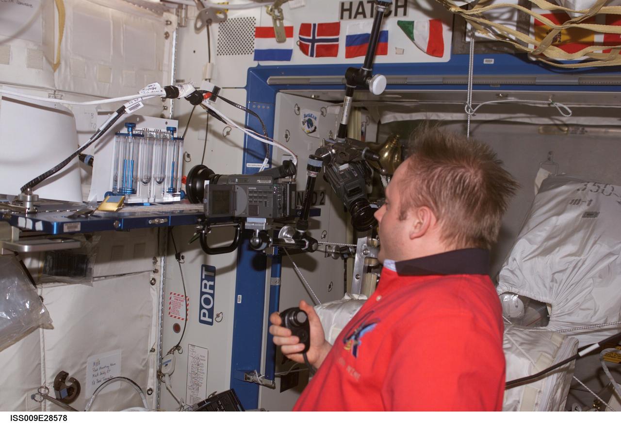ISS009-E-28578 (28 August 2004) --- Astronaut Edward M. (Mike) Fincke, Expedition 9 NASA ISS science officer and flight engineer, performs one of multiple tests of the Capillary Flow Experiment (CFE) investigation in the Destiny laboratory of the International Space Station (ISS). CFE observes the flow of fluid, in particular capillary phenomena, in micro-G.