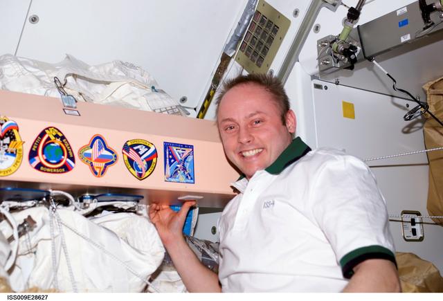 NASA image: Fincke with Expedition 9 mission patch sticker on panel in the Node 1 module during Expedition 9