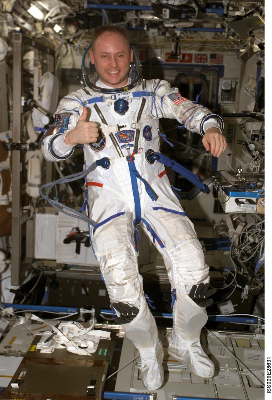 ISS009-E-28631 (7 July 2004) --- Astronaut Edward M. (Mike) Fincke, Expedition 9 NASA ISS science officer and flight engineer, wearing a Russian Sokol suit, gives a “thumbs up” as he floats in the Destiny laboratory of the International Space Station (ISS).