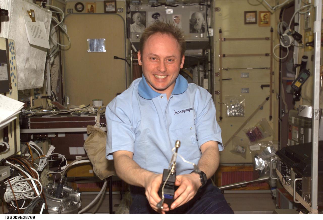 ISS009-E-28769 (14 October 2004) --- Astronaut Edward M. (Mike) Fincke, Expedition 9 NASA ISS science officer and flight engineer, uses a Dual Sorbent Tube and its associated pump to take routine air samples in the Zvezda Service Module of the International Space Station (ISS).