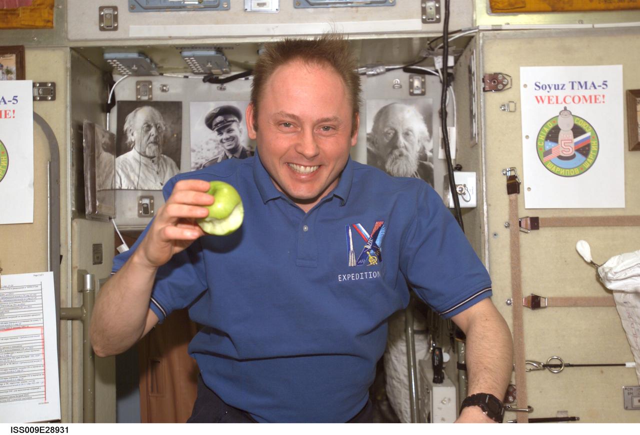 ISS009-E-28931 (16 October 2004) --- Astronaut Edward M. (Mike) Fincke, Expedition 9 NASA ISS science officer and flight engineer, enjoys eating a fresh apple in the Zvezda Service Module of the International Space Station (ISS).