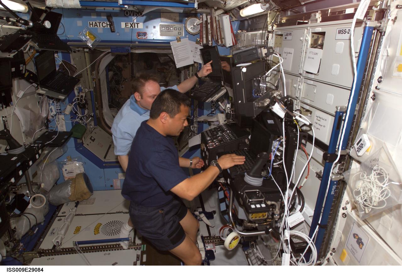 ISS009-E-29084 (18 October 2004) --- Astronaut Edward M. (Mike) Fincke (partially obscured), Expedition 9 NASA ISS science officer and flight engineer, takes astronaut Leroy Chiao, Expedition 10 commander and NASA ISS science officer, through a familiarization session with the Mobile Service System (MSS) and hands-on experience with the Canadarm2, or Space Station Remote Manipulator System (SSRMS) in the Destiny laboratory of the International Space Station (ISS).