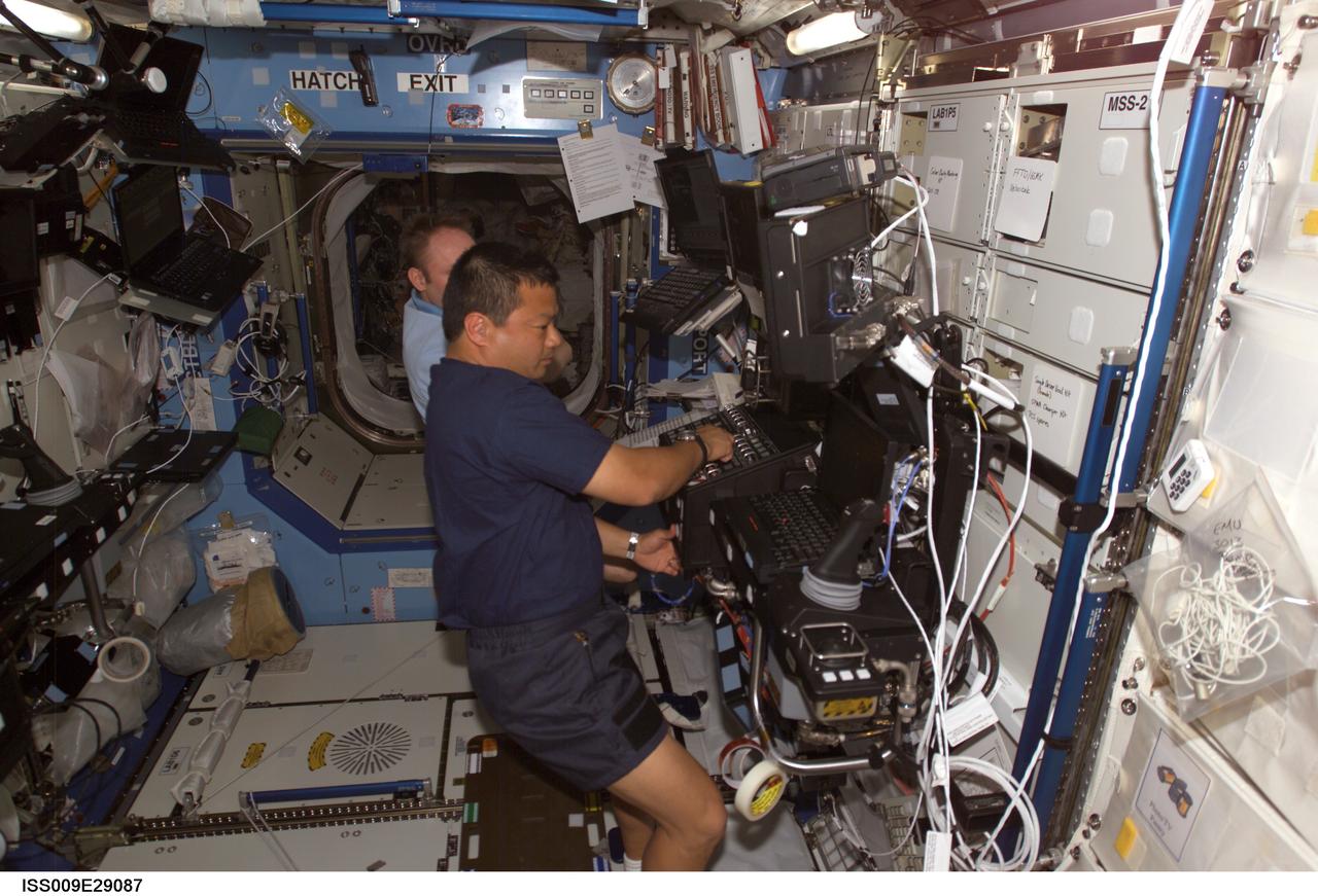 ISS009-E-29087 (18 October 2004) --- Astronaut Edward M. (Mike) Fincke (partially obscured), Expedition 9 NASA ISS science officer and flight engineer, takes astronaut Leroy Chiao, Expedition 10 commander and NASA ISS science officer, through a familiarization session with the Mobile Service System (MSS) and hands-on experience with the Canadarm2, or Space Station Remote Manipulator System (SSRMS) in the Destiny laboratory of the International Space Station (ISS).